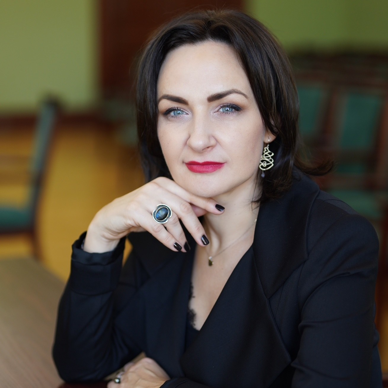 Dr. Eglė Vaidelytė sėdi prie stalo, pasitempusi, vilkinti juodą švarką, ranką parėmusi smakrą. Ji yra projekto vyriausioji mokslo darbuotoja, profesorė.